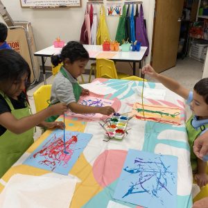 Students painting with string